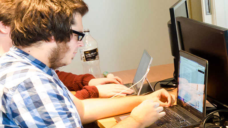 Co-founder Brett Cosgriff looking at laptop in GTG Network Melbourne Office