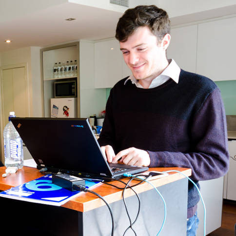 Employee looking at laptop screen on standing desk in GTG Network's Melbourne Office